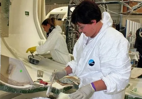photo dans l’usine compin de mauves-sur-huisne, dans le perche, les opératrices appliquent de la résine sur une tête de francilien.
