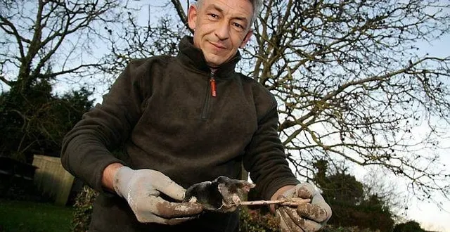 photo éric donon, tenant un piège traditionnel qu'il utilise pour attraper les taupes.
