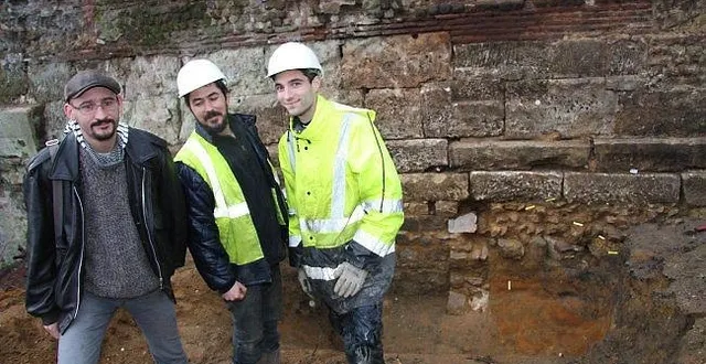 photo au pied de cette portion de muraille où travaillent actuellement les archéologues (de gauche à droite, olivier gastineau, vincent bernollin, et hugo meunier), des traces d'empierrement correspondant à un trottoir de circulation.