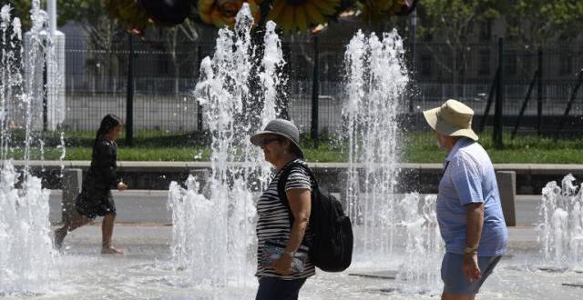 photo des passants se rafraîchissent en passant près d'une fontaine, à lyon, mercredi 1er août.