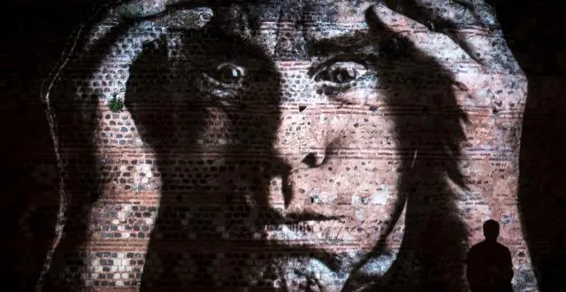 photo un passant joue avec son ombre sur l’un des portraits situé sur le quai louis-blanc. &copy; ouest-france