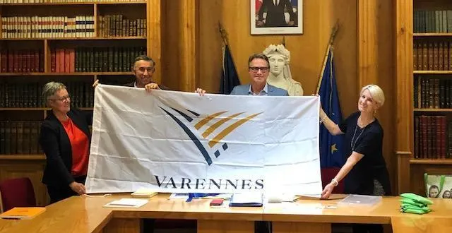 photo martin damphousse et son épouse hélène (à droite) ont offert à la municipalité et à bécon-echanges-amitiés représentés respectivement par marie-ange fouchereau, maire, et pierre-pascal bigot, président (à gauche), entre autres cadeaux, le drapeau de la ville de varennes. &copy; ouest-france
