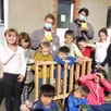 photo les enfants, encadrés par jacky, meggy et sandrine, sont très fiers de leur réalisation collective : un jeu « puissance 4 » géant, en bois.