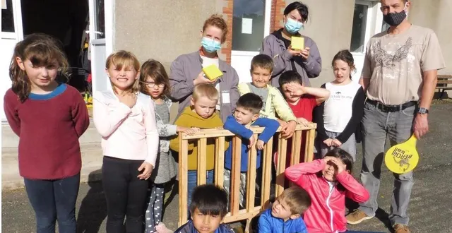 photo les enfants, encadrés par jacky, meggy et sandrine, sont très fiers de leur réalisation collective : un jeu « puissance 4 » géant, en bois.