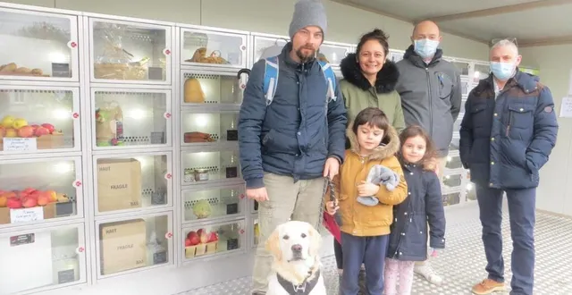 photo la famille rossard, habitante du village, mickaël valluet, salarié du petit pavillon, et philippe pousse, l’arboriculteur à l’initiative du projet, devant le distributeur de fruits, légumes et produits locaux. &copy; ouest-france