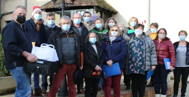 photo à gauche : xavier frénot, restaurateur, les mains chargées de contenants repas, et jean-denis guibert, maire, entourés des bénévoles venus prendre en charge les repas pour une distribution. &copy; ouest-france
