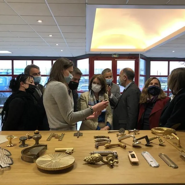 photo au centre, émilie morvan, pdg de l’entreprise baguès-bronzes de france à tinchebray-bocage montre une poignée de porte en bronze à françoise tahéri, préfète de l’orne.  ©  ouest-france