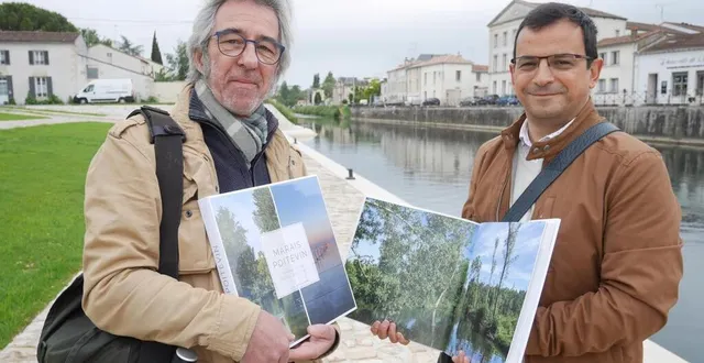 photo  michel paradinas et yannis suire avec l’ouvrage « marais poitevin », ce vendredi 21 mai, sur le site de la cale du port à niort.  &copy;  co – gabin chamereau 