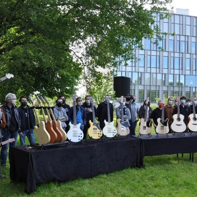 photo élèves et formateurs derrière les guitares réalisées.  ©  le maine libre