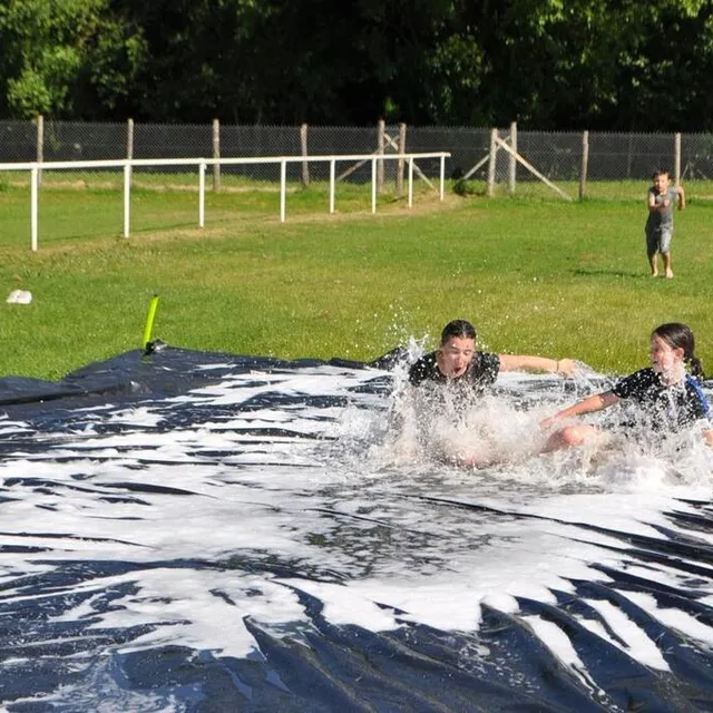photo glissades sur la bâche recouverte d’eau savonneuse : un rafraîchissement très apprécié.  ©  le maine libre