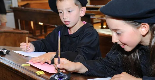 photo  les enfants apprécient de revêtir la tenue des écoliers de 1900.  &copy;  p. wall. 