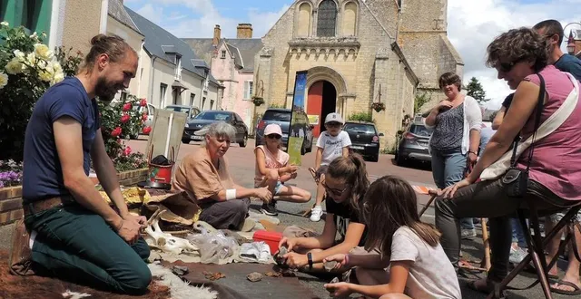 photo  petits et grands se prennent au jeu et tentent de faire du feu… pas facile, il faudra revenir pour peaufiner la technique !  &copy;  le maine libre 