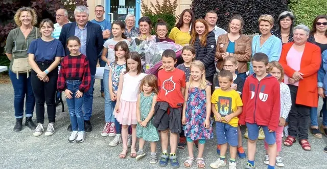 photo  emmanuelle chrétien (au milieu), pour un au-revoir, derrière son bouquet de fleurs. elle est entourée de sa fille, des élus, parents et enfants de la commune.  &copy;  ouest-france 