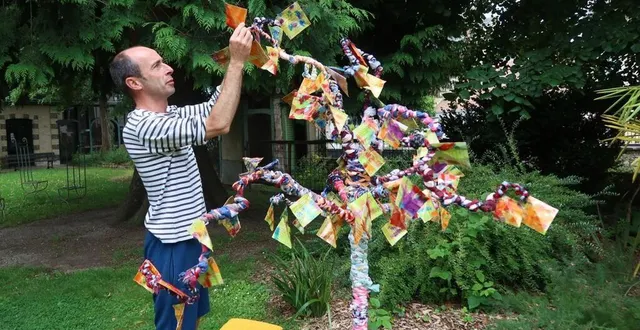 photo  jérôme côme, le directeur du festival saint-lyphard, répare les arbres fabriqués par les enfants, abîmés par la pluie.  &copy;  photo le maine libre 