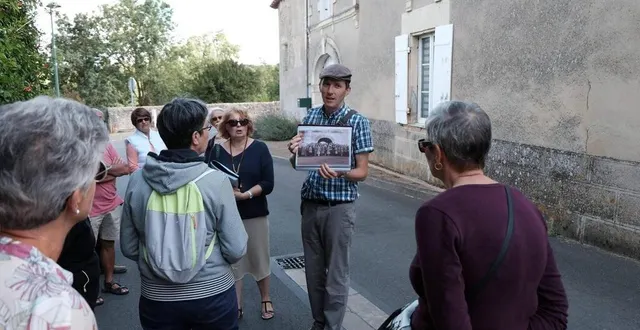 photo  sébastien maurin montre une photo ancienne lors de la visite du bourg de missé.  &copy;  archives co 