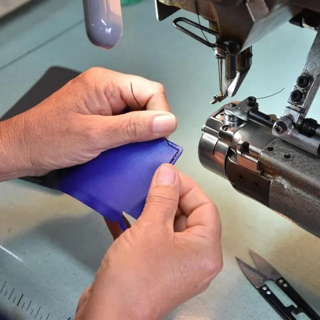 photo après avoir collé les rembords, la maroquinière pique le cuir à la machine à coudre pour bien fixer le cuir.  ©  ouest-france