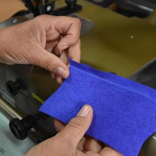 photo à l’aide d’une machine à parer, la maroquinière affine les bords du cuir qu’elle va ensuite replier pour créer des rembords.  ©  ouest-france