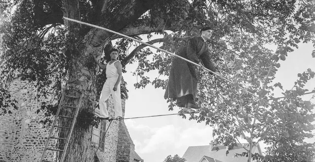 photo  en août 1957, devant l’église de fillé, l’abbé baron s’avance avec prudence sur un fil de funambule. un exploit destiné à financer la réparation de l’église.  &copy;  agip - bridgeman images 