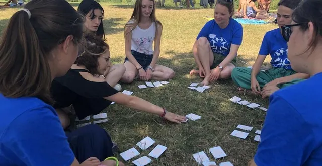 photo  une partie des jeunes de l’association wemps (week-end mission prière service) jouent aux cartes sur l’herbe de la base de loisirs de la monnerie à la flèche, dimanche 15 août 2021.  &copy;  ouest-france 