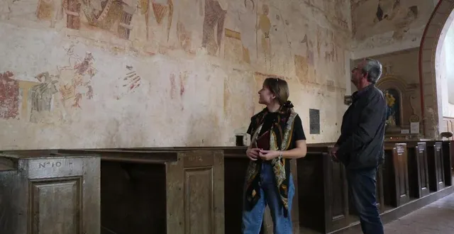photo  clémence bruon et hervé delaune, devant une partie des fresques de l’église saint-hilaire d’asnières-sur-vègre.  &copy;  le maine libre 