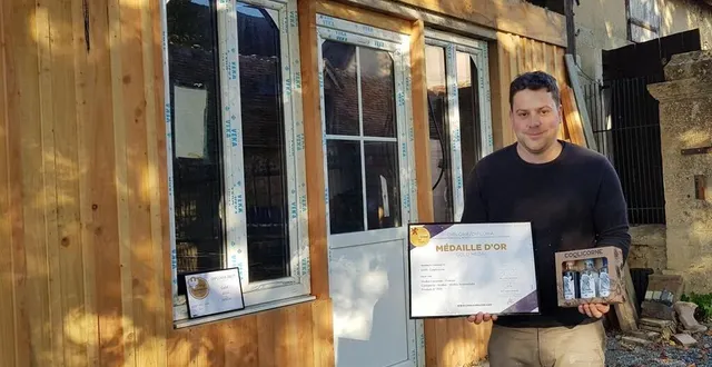 photo  ugo fuchs devant son nouveau local de stockage présente le coffret dégustation ainsi que ses diplômes et récompenses.  &copy;  le maine libre 