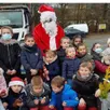 photo  les enfants sont heureux de poser près dru père noël. 