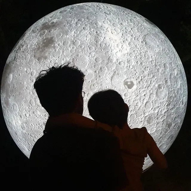 Père et fils devant une lune géante installée dans le parc de Tessé, au Mans, en septembre 2021. Romain Quette/@quette.romain photo père et fils devant une lune géante installée dans le parc de tessé, au mans, en septembre 2021. © romain quette/@quette.romain