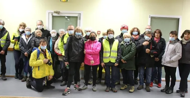 photo  au départ d’une marche nocturne téléthon, bertrand linquette, coordinateur du comité téléthon de perseigne, genoux à terre, entouré de bénévoles et marcheurs.  &copy;  ouest-france 