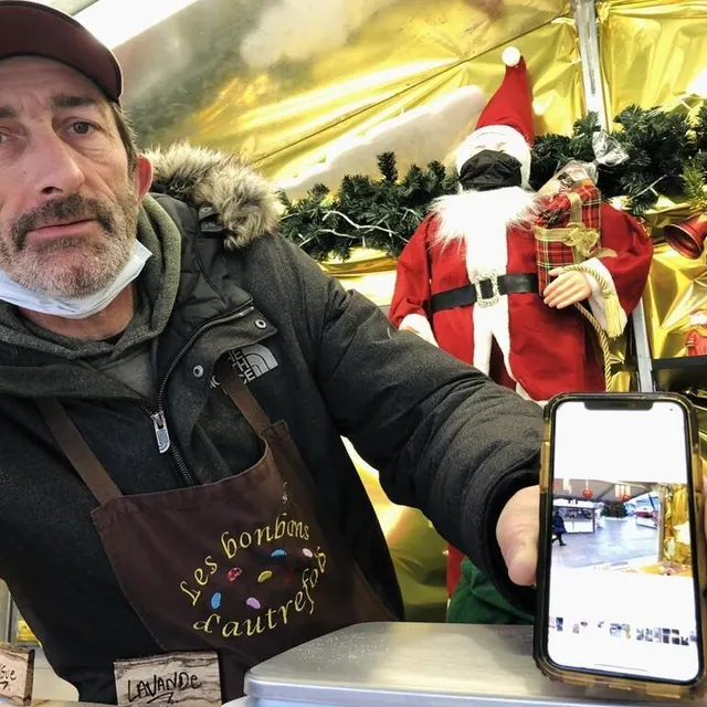 photo hermann, employé d’un chalet de confiseur, expose une photo prise l’après-midi du 24 décembre : un marché de noël quasi-vide.  ©  le maine libre