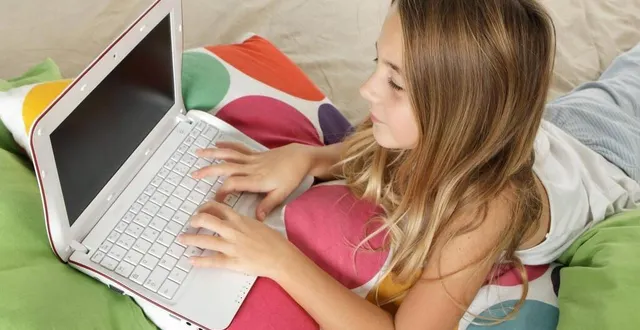 photo  une fillette de 11 ans utilise un ordinateur portable allongée sur le lit de sa chambre. (photo d’illustration)  &copy;  archives philippe devanne 