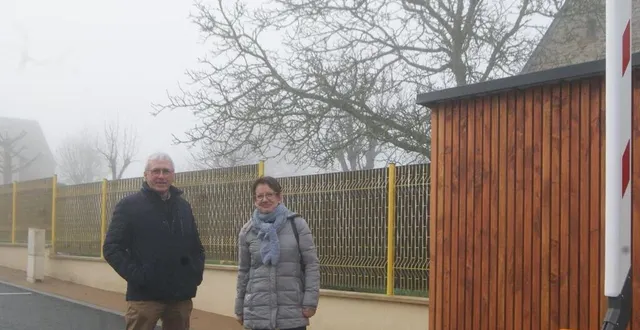 photo  le maire, gilles rabache, avec son adjointe à la vie scolaire devant le nouveau local à poubelles et la barrière qui sécurise la rue de l’école.  &copy;  ouest-france 