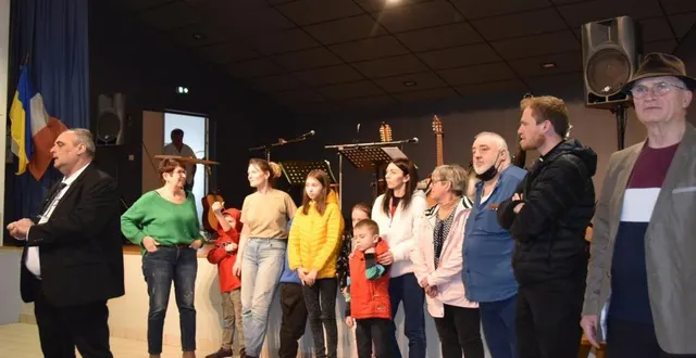 photo  derrrière le maire faisant, les responsables d’association entourent les deux familles ukrainiennes accueillies dans les environs.  &copy;  le maine libre 