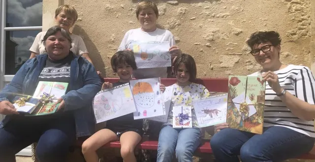 photo  astrid et salomé en compagnie de l’équipe de la bibliothèque présentent les dessins gagnants.  &copy;  le maine libre 