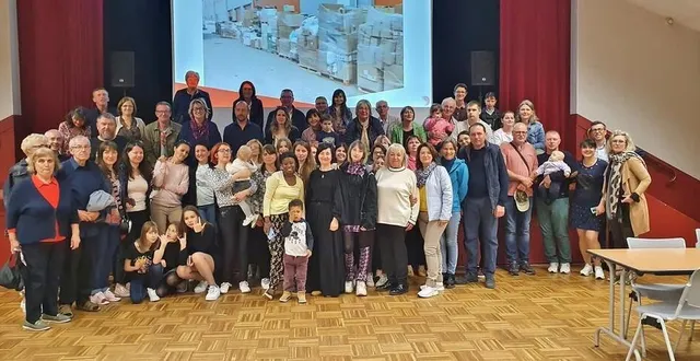 photo  des réfugiés ukrainiens, des familles d’accueil françaises et des salariés de l’entreprise salesky réunis lors d’une photo de groupe à la salle des fêtes de solesmes, le 22 avril 2022.  &copy;  salesky 