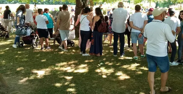 photo  à l’ombre des essences de l’arboretum, les familles assistent à une danse des élèves. 
