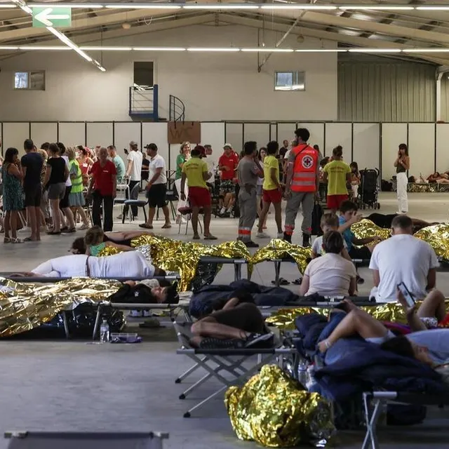 photo des vacanciers sont couchés dans des couvertures de survie après avoir été évacués de leur camping, après un incendie vers gujan-mestras, dans l’ouest de la france, le 13 juillet 2022.  ©  thibaud moritz / afp