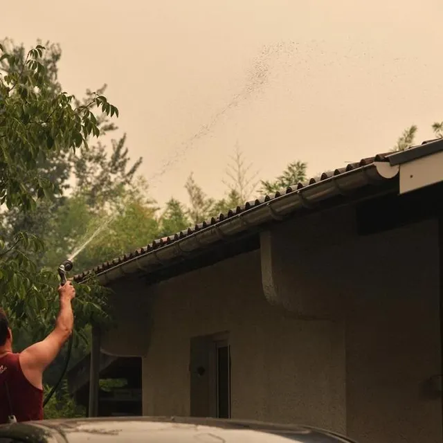 photo un habitant de cazaux arrose son toit avant d’être évacué.  ©  thibaud moritz / afp
