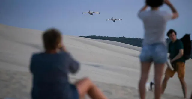 photo  des personnes prennent des photos de canadairs survolant la dune du pyla à la teste-de-buch, en gironde, le 14 juillet 2022.  &copy;  thibaud moritz / afp 