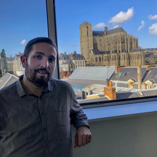 photo wilfrid tocqueville dans les nouveaux locaux de sweet fm avec vue sur la cathédrale saint-julien  ©  le maine libre