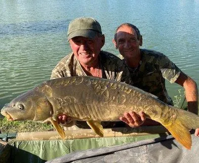 photo  gérard accompagné d’un ami pêcheur qui l’a aidé à sortir la carpe de l’eau.  &copy;  le maine libre 