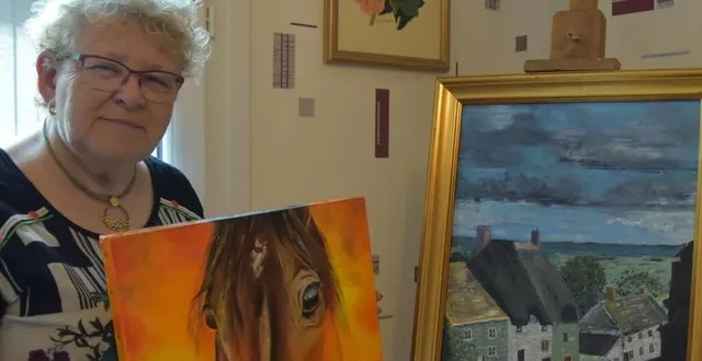 photo  clairette présentant un de ses tableaux aux côtés d’une toile de jeannine.  &copy;  le maine libre 