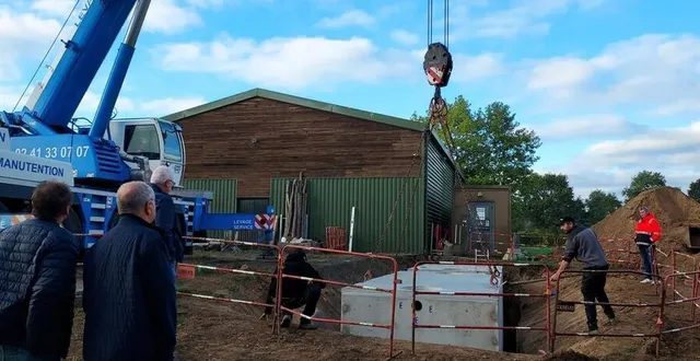 photo  les élus de saint-melaine-sur-aubance (maine-et-loire), dominique forest, le maire, jean-jacques dulong et laurent delepierre ( de dos, à gauche ) assistent à la pose des deux cuves réalisée par les entreprises spécialisées. les deux cuves sont alignées et reliées entre elles pour recevoir les eaux de pluie du toit du bâtiment communal situé en arrière-plan.  &copy;  ouest-france 