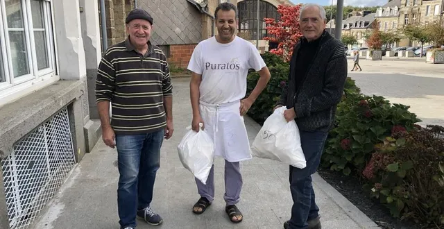 photo  patrick picard, président de la confrérie des gastronomes de flers et daniel catherine, vice-président, entourent mohammed bihich, boulanger des délices de flers, qui a préparé plusieurs centaines de becs de flers pour la foire de montilly-sur-noireau (orne).  &copy;  ouest-france 