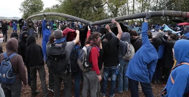 photo  les manifestants exhibent le tuyau arraché en guise de trophée.  &copy;  co – benoit felace 