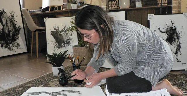 photo  assise par terre, artem manon peint des aquarelles en utilisant uniquement la couleur noire.  &copy;  ouest-france 