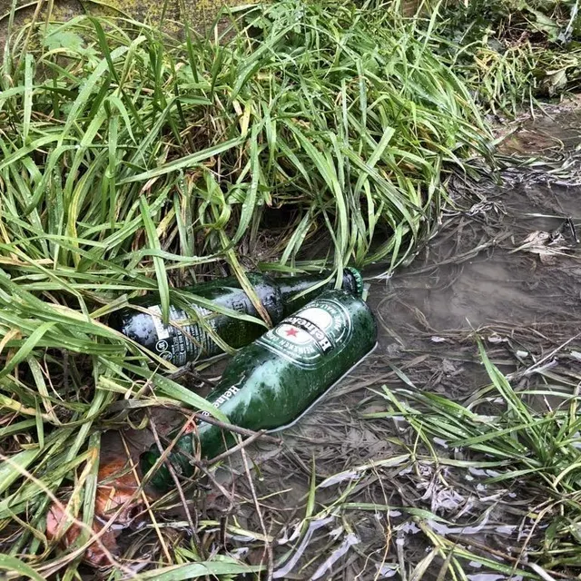 photo au pied d’un mur sur le parking où un jeune homme a été tué, des bouteilles de bière jonchent le sol.  ©  le maine libre