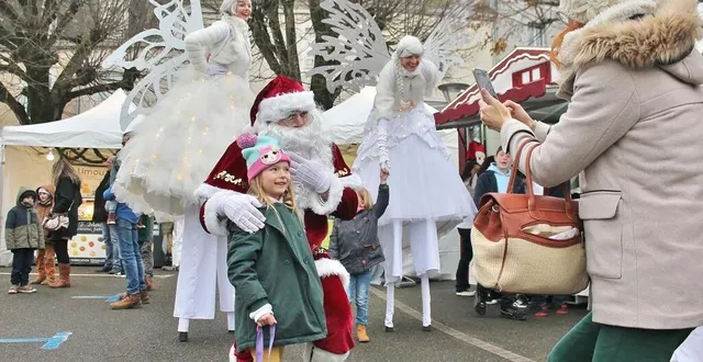 photo  les enfants ont posé avec le père noël et les elfes blancs montés sur échasses, au milieu du marché des exposants, place de la république, dimanche 4 décembre 2022, à sablé-sur-sarthe.  &copy;  ouest-france 