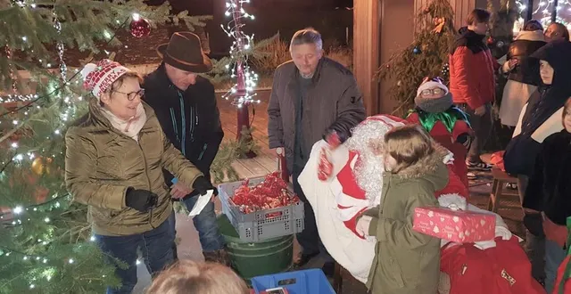 photo  annick dutertre, gerard lantenois, daniel bellaye, aident le père noël à distribuer les cadeaux. 