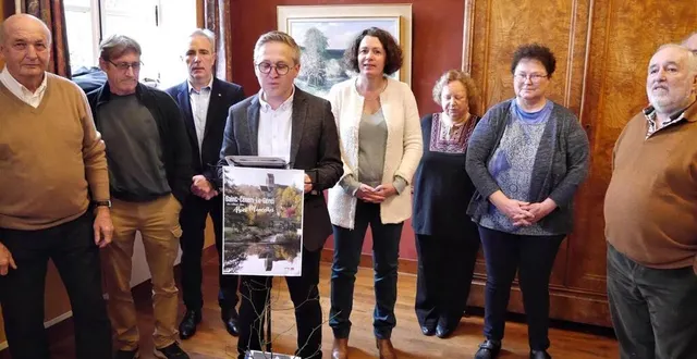 photo  entouré des membres du conseil municipal et des conseillers départementaux, le maire, richard marquet, présente la belle affiche de saint-céneri offerte par éric garnier.  &copy;  ouest-france 