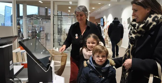 photo  ophélie, venue de vion avec pierre et lou, devant la borne de retour des livres empruntés. yvette marçais, la directrice de la médiathèque, montre le fonctionnement de ce nouvel automate pour le prêt et le retour des ouvrages.  &copy;  le maine libre 